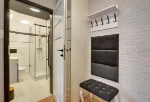 Łazienka z czarną ławką obok ściany z cegły w obiekcie Apartament Szmaragdowy w mieście Karpacz