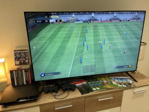 a large flat screen tv on a table with a soccer game at Villa Nevada - Adults only in Bad Schandau