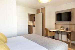 a hotel room with a bed and a table with chairs at Residhome Toulouse Ponts Jumeaux in Toulouse