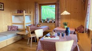 a room with two tables and a bunk bed at Ferienbauernhof Masunerhof in Fiè