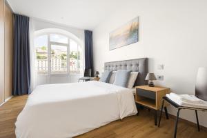 a bedroom with a large white bed and a window at Design et charme, 100m2 face à la Saône in Lyon