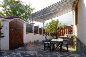 a patio with a table and chairs and a wooden door at Sunflower Villa in Tutrakantsi
