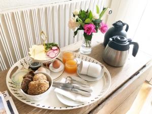 una mesa con una bandeja de alimentos y flores para el desayuno en Kirkevængets mini Bed and Breakfast, en Kruså