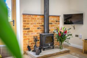 a brick fireplace in a living room with a stove at Brecks Farm - The Parlour in York