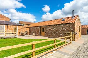 a property with a wooden fence in front of a building at Brecks Farm - The Parlour in York