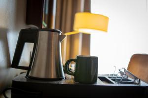 une cafetière et une tasse sur une table dans l'établissement Hotel Atlantic Agdal, à Rabat