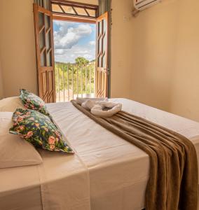 łóżko z kocem i oknem w obiekcie Village Funchal, Lençóis w mieście Lençóis
