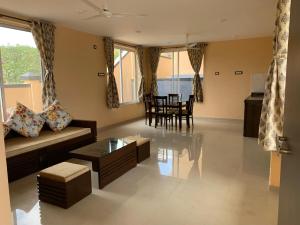 a living room with a couch and a table at ROYAL MEADOWS - IGATPURI Bungalow C in Igatpuri