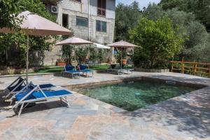 a pool with chairs and umbrellas in a yard at Casa Aprea in Sorrento