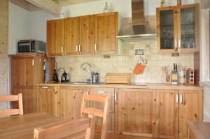 a kitchen with wooden cabinets and a wooden table at Danielówka in Pępowo