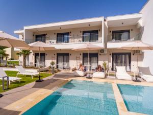 a villa with a swimming pool in front of a house at B&D Luxury Suites in Skala Potamias