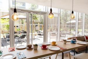a dining room with a table and a large window at Residhome Toulouse Ponts Jumeaux in Toulouse +6 photos