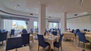 a dining room with tables and blue chairs at Edison Hotel Seaview in Sottomarina