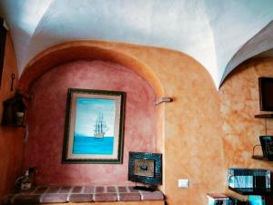 a room with a painting of a boat on the wall at Casa Rustica in Dorgali