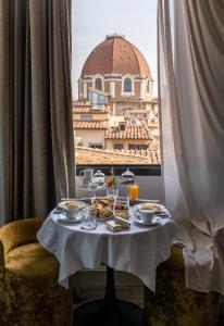 un tavolo con cibo e una vista su un edificio di Hotel Cerretani Firenze - MGallery Collection a Firenze