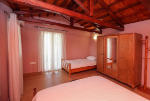 um quarto com uma cama, um armário e uma janela em Traditional Guesthouse Asimakis Anifion em Anífion