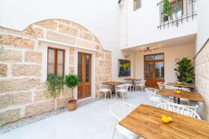 an outdoor patio with wooden tables and chairs at Flor de Mandarina in Sa Pobla