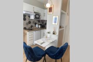een keuken met blauwe stoelen en een wastafel bij APPARTEMENT DE CHARME EN CENTRE VILLE in Toulouse