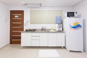 La cuisine est équipée d'un réfrigérateur et d'un évier. dans l'établissement Condomínio Belas Praias, à Porto de Galinhas