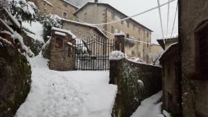 a snow covered alley with buildings and a gate at Affittacamere Ferrari in Pescaglia