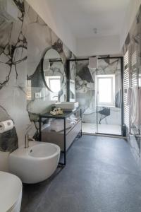 bagno con lavandino, servizi igienici e specchio di Sonrisa suites a Taranto