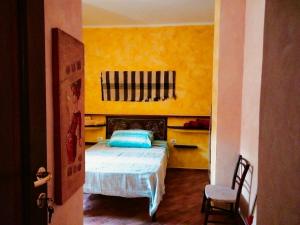 1 dormitorio con cama y pared amarilla en Casa Rustica, en Dorgali