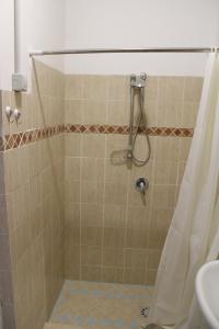 a shower with a shower curtain and a sink at Appartamento in villa pianterreno in Acireale