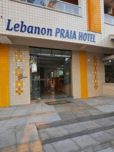 a lebanon plaza hotel sign in front of a building at Lebanon Praia Hotel in Tramandaí