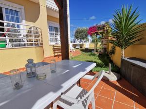 een tafel en stoelen op het balkon van een huis bij Windmill Ericeira in Ericeira