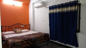 a bedroom with a bed and a blue curtain at Nandini Paying Guest House in Udaipur