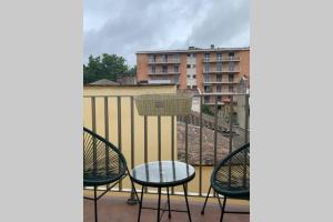 einen Balkon mit Stühlen, einem Tisch und einem Gebäude in der Unterkunft Joli appartement haut standing en hyper centre in Toulouse