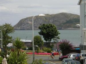 a person riding a bike next to a body of water at Mostyn House in Llandudno