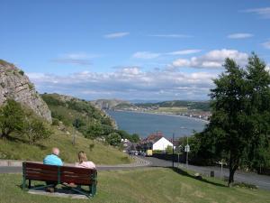 two people sitting on a bench looking at the water at Mostyn House in Llandudno +25 photos