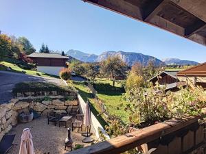an outdoor patio with umbrellas and a stone wall at Beautiful renovated chalet near ski resort France in Arâches-la-Frasse