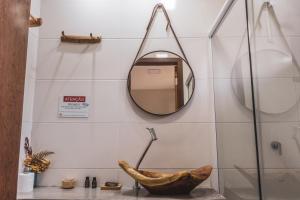 a bathroom with a mirror on the wall at Chalés das Margaridas in Vale do Capao