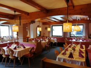 a dining room with tables and chairs and windows at Hotel Christoffel - Wildschönau PREMIUMKARTE in Niederau