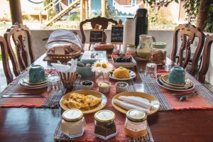 a table with plates of food on top of it at Chalés das Margaridas in Vale do Capao