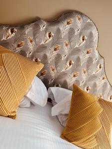 a bed with yellow and white pillows on it at The Lounge Hotel & Bar in Penrith