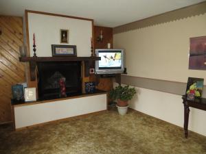 a living room with a tv and a fireplace at Wild Rose Bed & Breakfast in Saskatoon