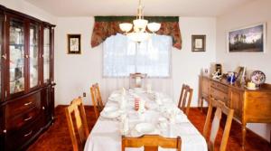 a dining room with a white table and chairs at Wild Rose Bed & Breakfast in Saskatoon