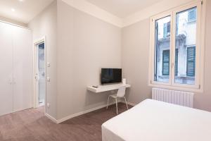 una camera da letto con un letto, una scrivania e una TV di Good night Romeo - Eleganti Dimore a Verona