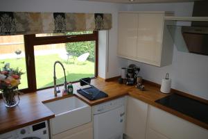 Beautiful, 2 Bedroom Cottage في Selstead: مطبخ مع حوض وحاسب محمول على منضدة