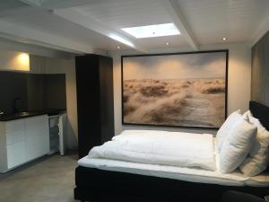 una camera da letto con un letto e un dipinto sul muro di Centre beach lodge (2) a Zandvoort