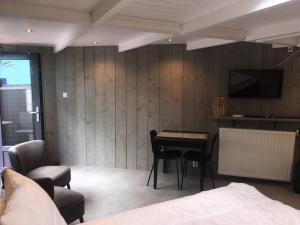 una camera da letto con un letto, un tavolo e una TV di Centre beach lodge (2) a Zandvoort
