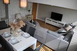 sala de estar con sofá, mesa y TV en Beautiful, 2 Bedroom Cottage, en Selstead