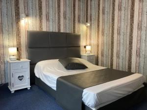 Una cama o camas en una habitación de Hôtel Le Faisan