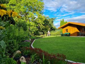 バート・フュッシンクにあるAparthotel Naturidyll - Wieserhofの黄色い家を背景にした庭園
