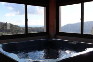 a bath tub in a room with three windows at Hotel Rural Los Jarales in Istán