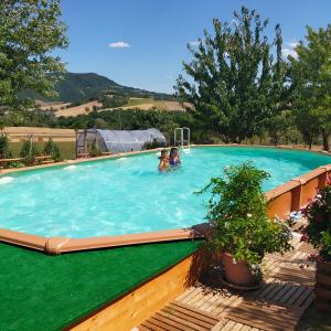 a swimming pool with two people in the water at MANSARDA VITI - Sguardo su Frontone - in Frontone