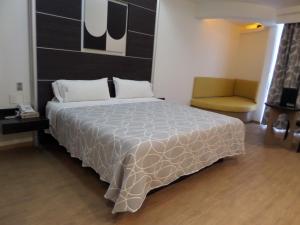 1 dormitorio con 1 cama grande y 1 silla en Novo Coapa, en Ciudad de México